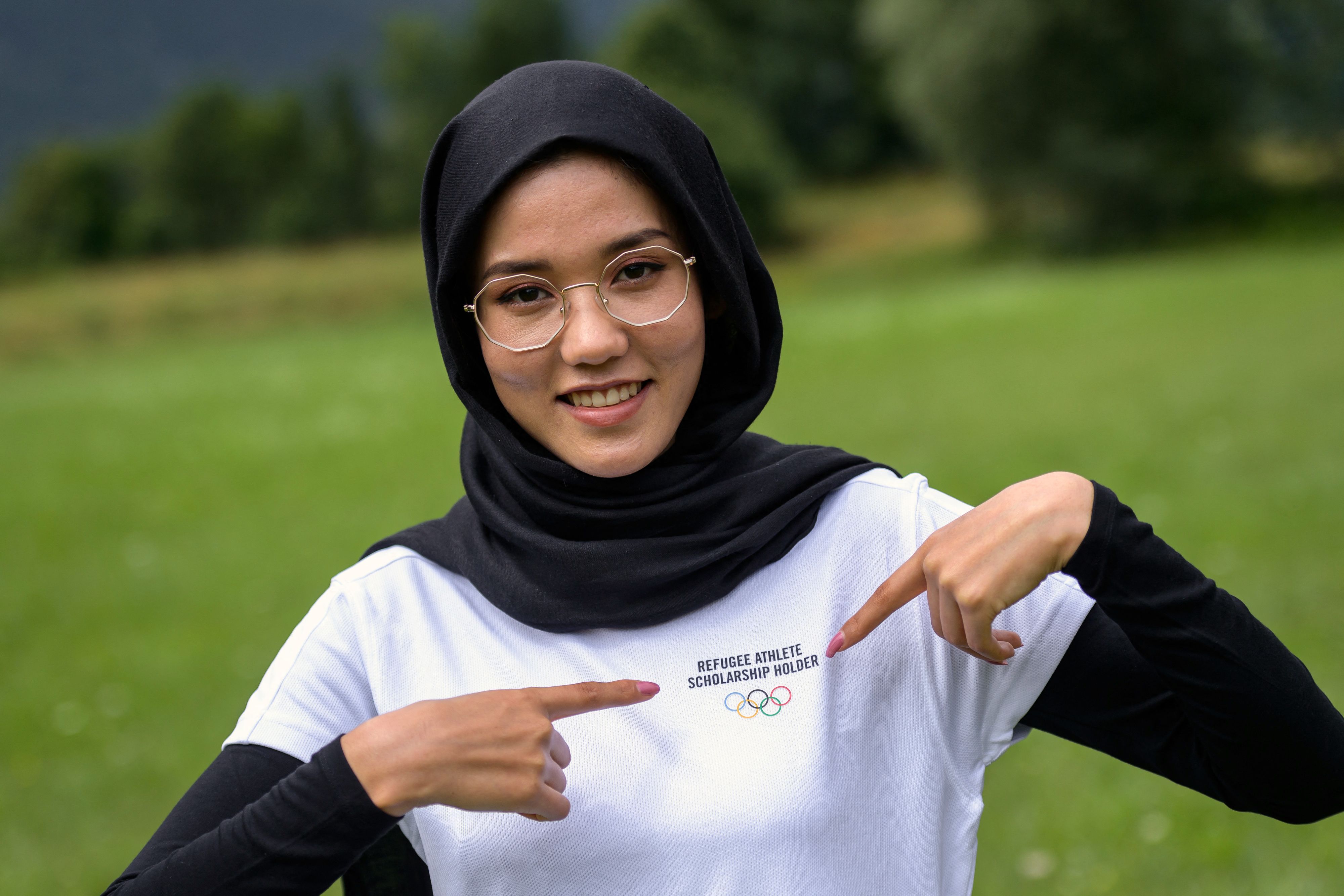 Afghan refugee road cyclist Masomah Ali Zada poses with her t-shirt adorned with the Olympics Rings at the World Cycling Centre (CMC) in Aigle on July 1, 2021 as she prepares to compete at the Tokyo Olympics