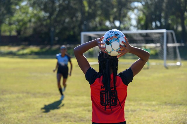 Soccer player throwing ball in