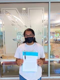 Aparna posing with passed legislation from Beyond Charity