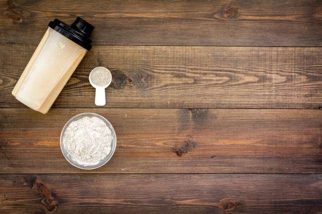 protein powder for fitness nutrition to start training on wooden background top view mock-up
