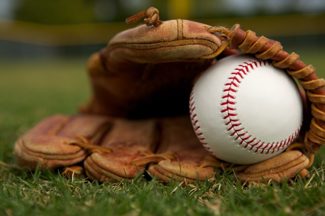 New Baseball in a Glove on the Outfield Grass