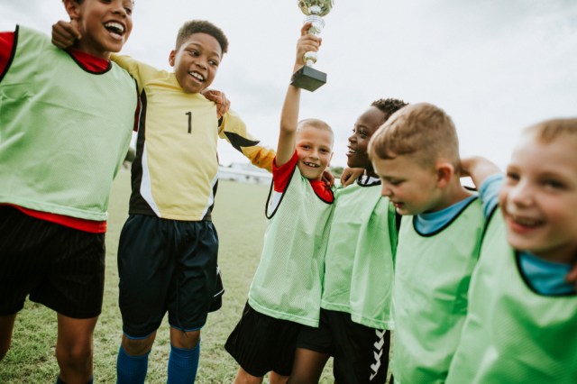 Young kids on the field celebrating their victory