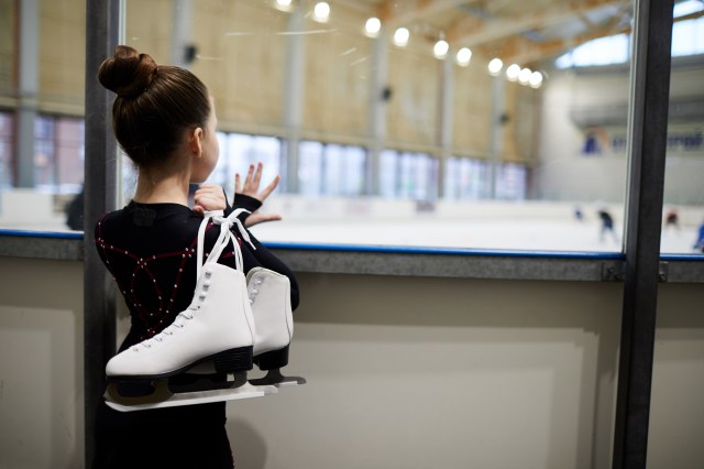 girl watching figure skaters on the ice