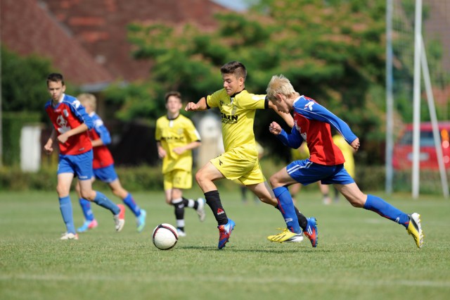 KAPOSVAR, HUNGARY - JULY 20: Unidentified players in action at the IX. Youth Football Festival match Minsk (red) (BLR) vs. Brasov (yellow) (ROM) on July 20, 2013 in Kaposvar, Hungary