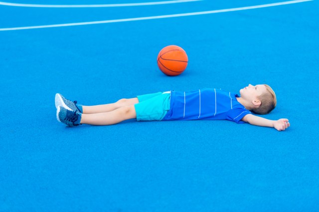 child laying on basketball court