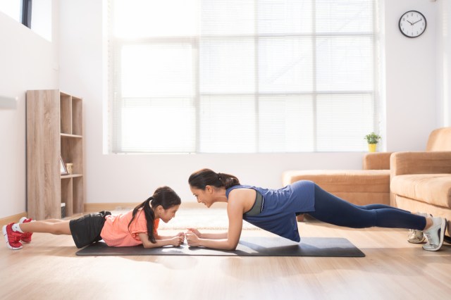 Asian mother and daughter exercising at home They are doing plank pose.