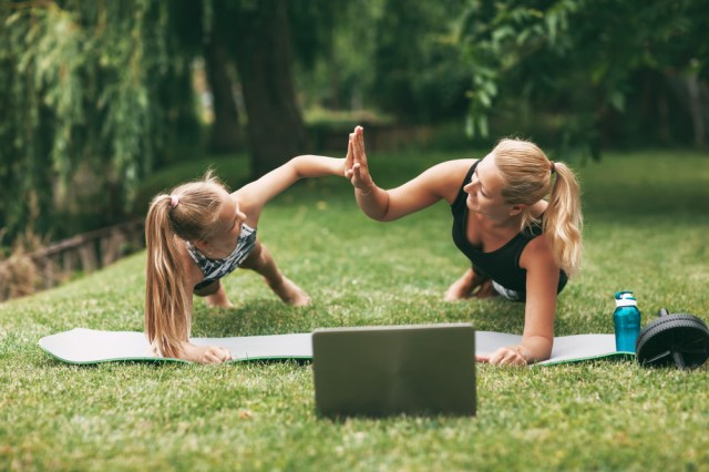 Mother and daughter practice online outdoors near their home during quarantine self-isolation during a pandemic.