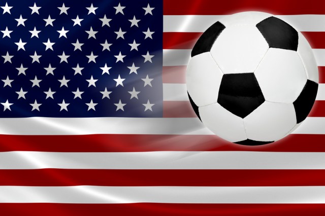 Ball streaks across the flag of United States, where soccer is a growing national passion.