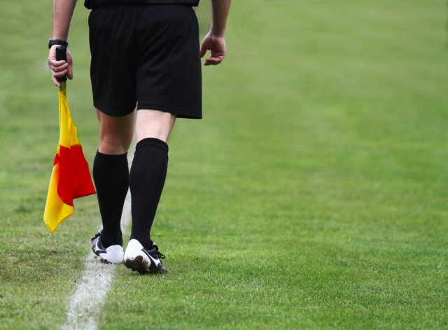 Soccer football referee linesman with a flag.