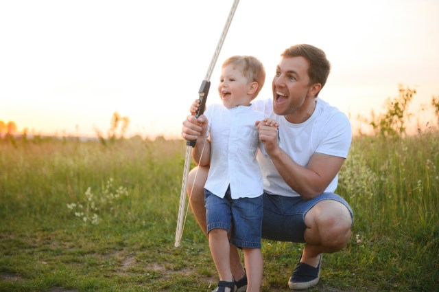 Father teaching son archery.