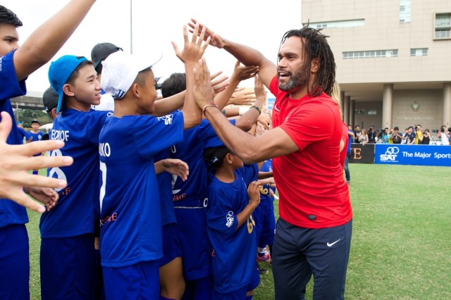 Christian Karembeu (red)poses with local child at the Global Legends Series coaching clinic, at the Thailand Sports Authority, on December 4, 2014 in Bangkok, Thailand.