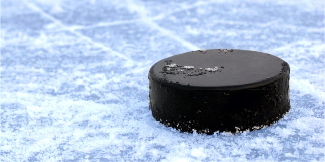black hockey puck on ice rink