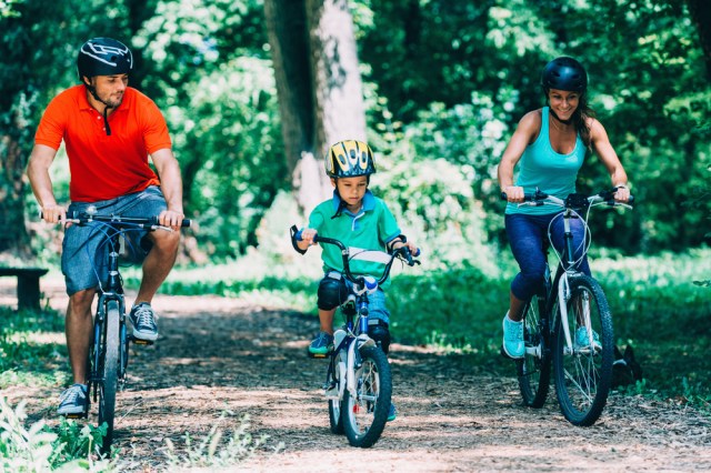 Cheerful family biking in park