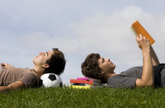 Two young students lying on the grass