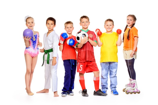 Group of joyful boys and a girls engaged in various sports posing together.