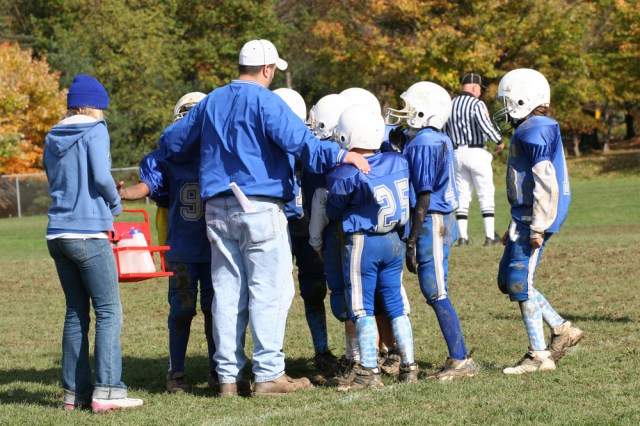 Youth Football Huddle with Coach